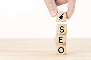 Search Engine Optimization - Human hand stacking SEO blocks